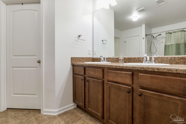 bathroom with a shower with curtain, vanity, and tile patterned flooring