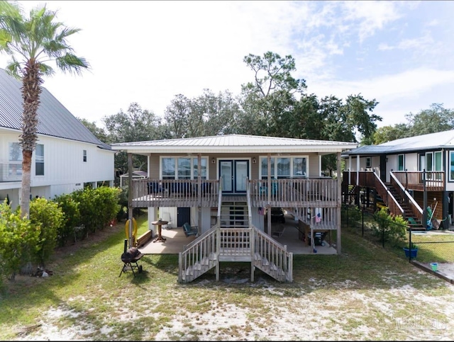 rear view of house featuring a deck and a lawn