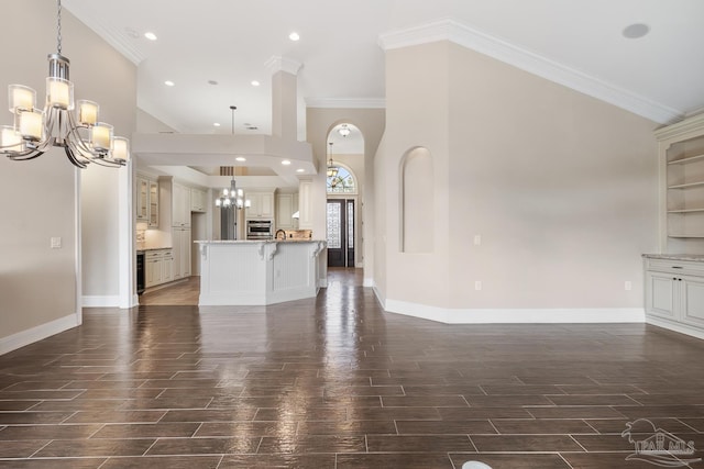 unfurnished living room with crown molding and a chandelier