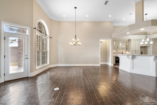 unfurnished living room featuring a chandelier, beverage cooler, ornamental molding, and dark hardwood / wood-style floors