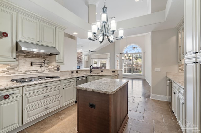 kitchen featuring stainless steel appliances, decorative backsplash, a notable chandelier, hanging light fixtures, and light stone counters