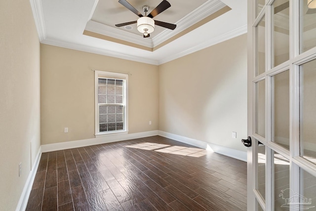 spare room featuring ceiling fan, dark hardwood / wood-style flooring, ornamental molding, and a raised ceiling