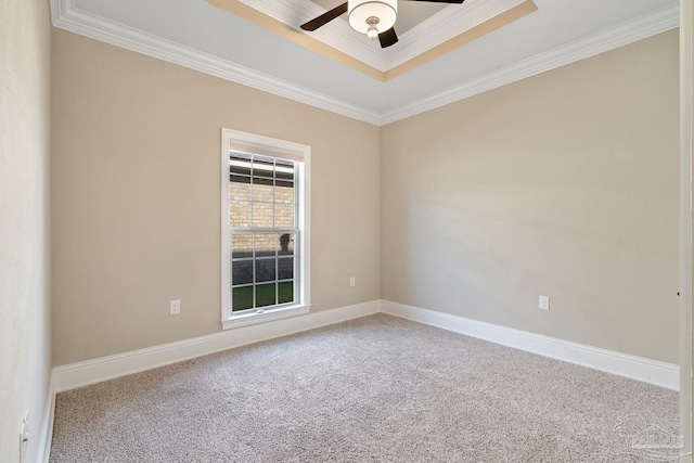 spare room with ceiling fan, carpet, a tray ceiling, and crown molding