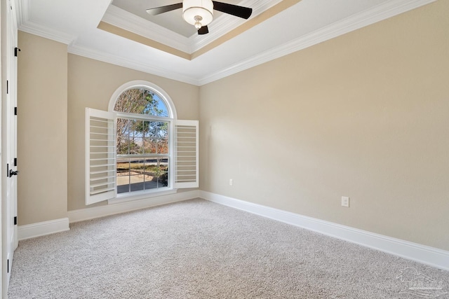 carpeted spare room with ceiling fan, crown molding, and a raised ceiling