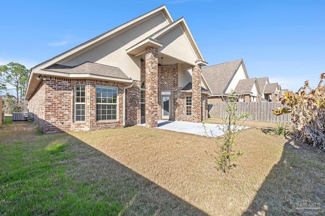 back of property featuring a lawn, central AC, and a patio