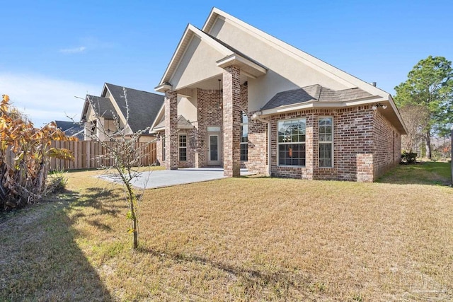 rear view of house with a lawn and a patio