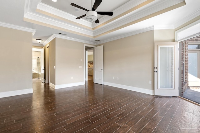 empty room featuring ceiling fan, a tray ceiling, and crown molding