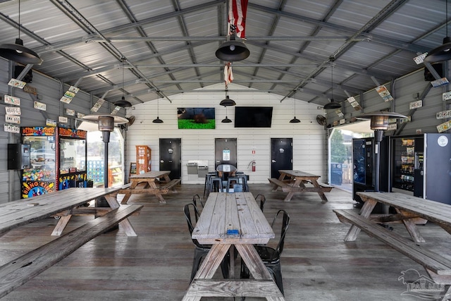 interior space featuring hardwood / wood-style floors, lofted ceiling, and wooden walls