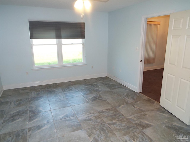 unfurnished room with baseboards and ceiling fan