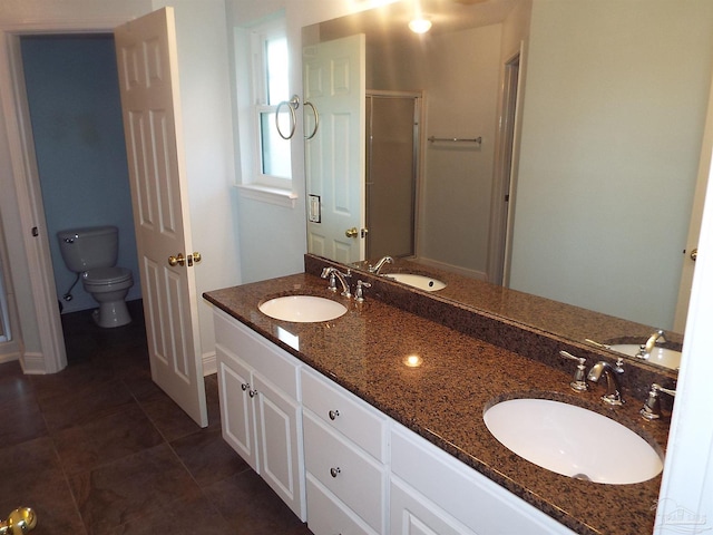 full bathroom with toilet, a shower stall, double vanity, baseboards, and tile patterned floors