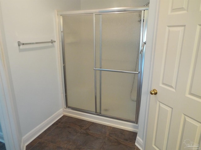 full bath with baseboards, a shower stall, and tile patterned flooring