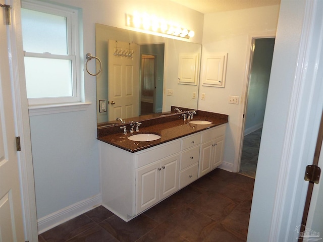 bathroom featuring double vanity, baseboards, and tile patterned floors