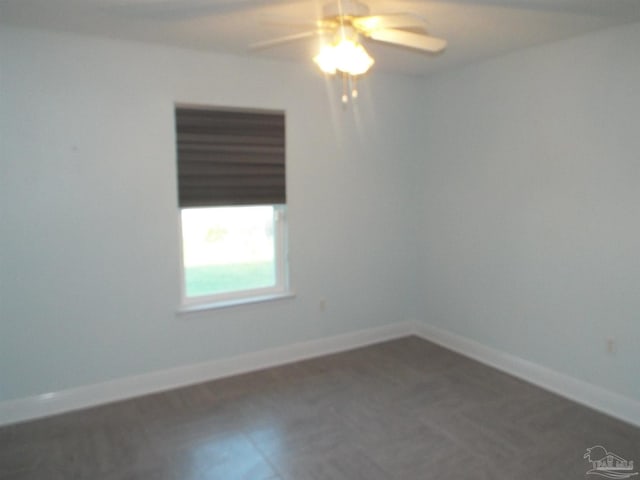 unfurnished room featuring a ceiling fan and baseboards