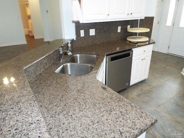 kitchen featuring dishwasher, a sink, white cabinets, and tasteful backsplash