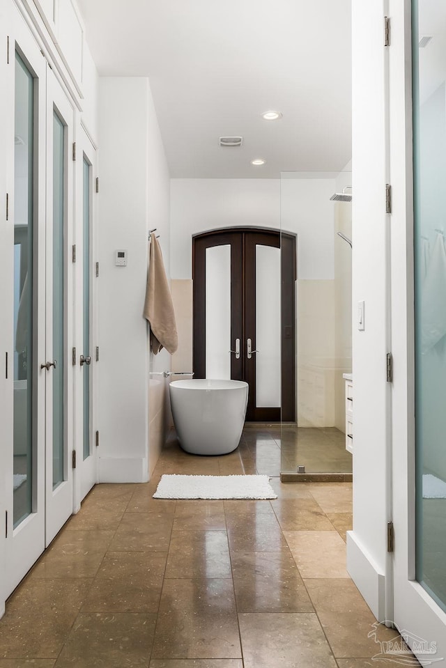 bathroom featuring a bath and french doors