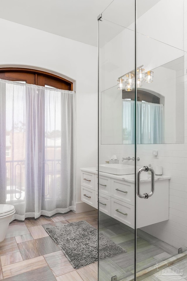 bathroom featuring vanity, toilet, and walk in shower