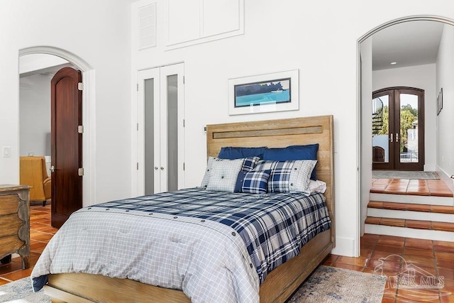 bedroom with french doors, tile patterned floors, access to exterior, and a closet