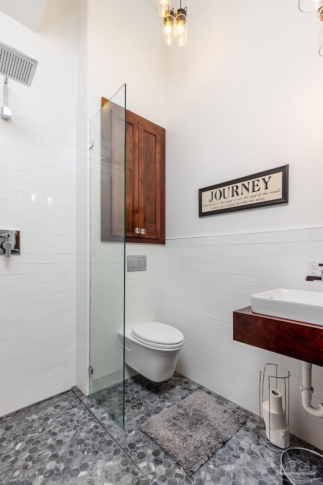 bathroom with tile walls, sink, toilet, and tiled shower