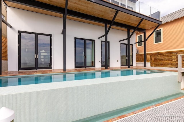 view of swimming pool featuring french doors