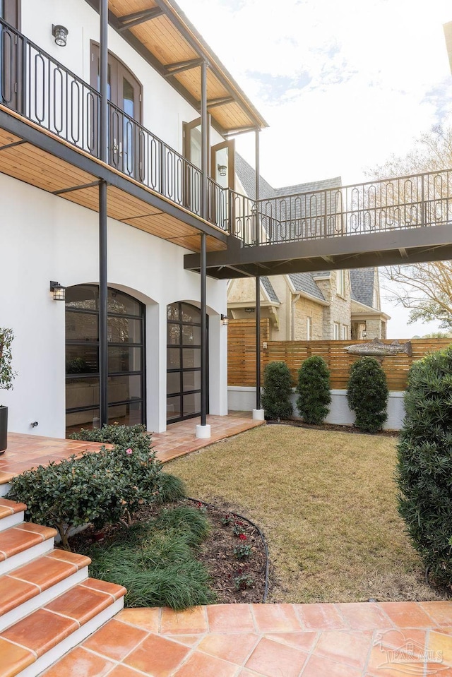 property entrance with a balcony and a lawn