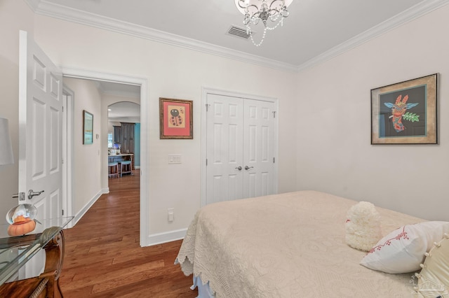5757 Cobble Creek Dr, Pace, FL 32571 - bedroom featuring arched walkways, ornamental molding, wood finished floors, baseboards, and a closet