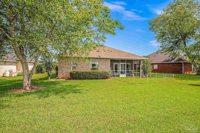 5757 Cobble Creek Dr, Pace, FL 32571 - rear view of house with a sunroom, a lawn, and brick siding