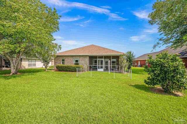 5757 Cobble Creek Dr, Pace, FL 32571 - rear view of house featuring a sunroom, a lawn, and brick siding