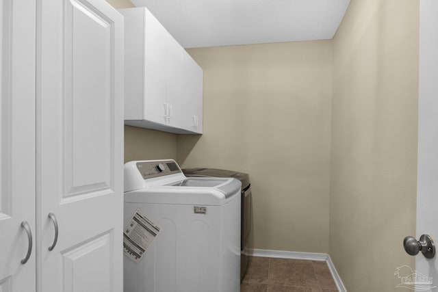 3774 Mcnemar Ct, Gulf Breeze, FL 32563 - laundry room with washing machine and clothes dryer, baseboards, cabinet space, and dark tile patterned flooring