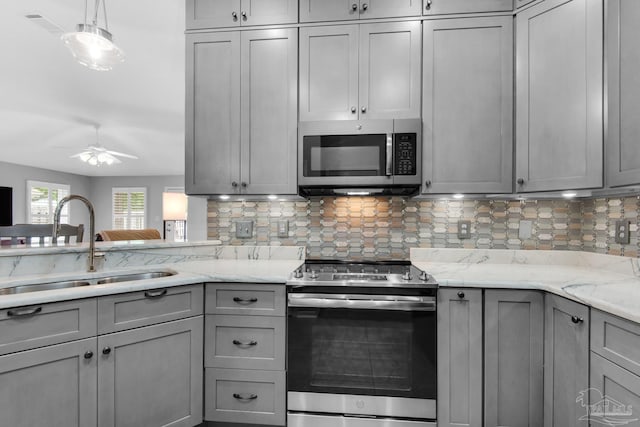 3774 Mcnemar Ct, Gulf Breeze, FL 32563 - kitchen with appliances with stainless steel finishes, gray cabinetry, a sink, tasteful backsplash, and a ceiling fan