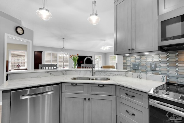 3774 Mcnemar Ct, Gulf Breeze, FL 32563 - kitchen featuring appliances with stainless steel finishes, a sink, gray cabinetry, decorative backsplash, and plenty of natural light