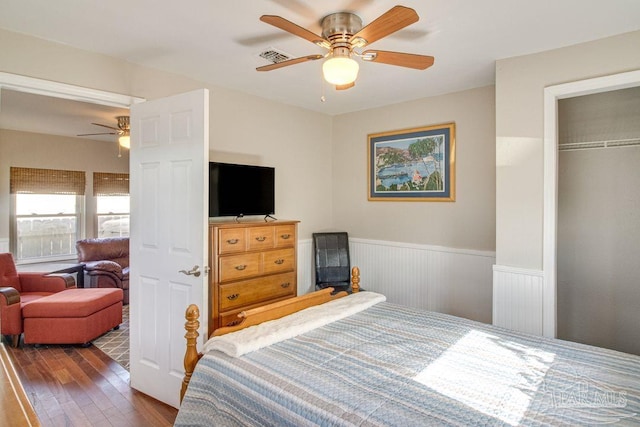 bedroom with ceiling fan, dark wood-type flooring, and a closet