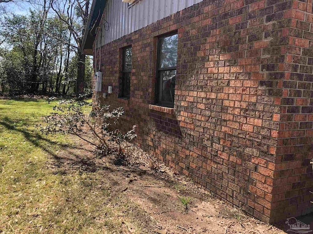 view of side of home with a yard and brick siding