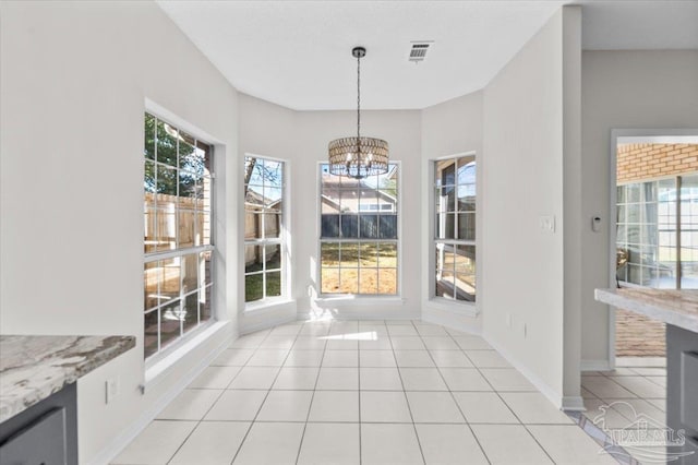 unfurnished dining area with baseboards, visible vents, a notable chandelier, and light tile patterned flooring