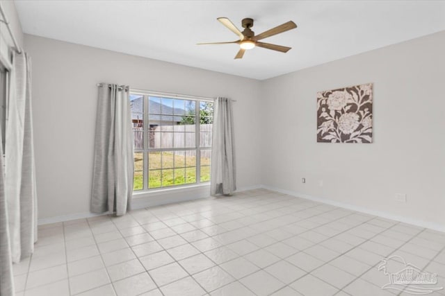 spare room with light tile patterned floors, ceiling fan, and baseboards