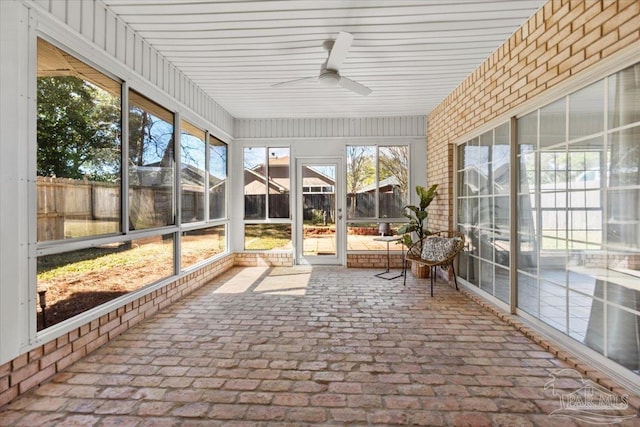 unfurnished sunroom with ceiling fan