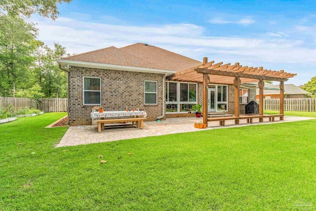 back of house featuring a lawn, a patio area, and a pergola