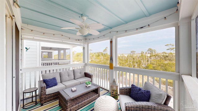 sunroom / solarium featuring beam ceiling, a wealth of natural light, and ceiling fan