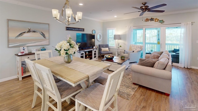 dining room featuring crown molding, ceiling fan with notable chandelier, and light hardwood / wood-style floors