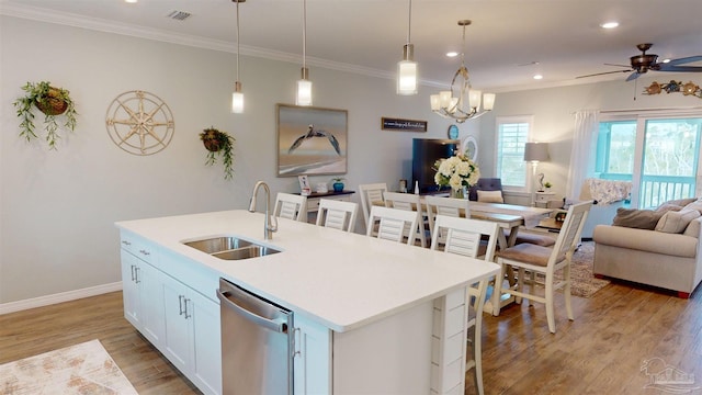 kitchen featuring sink, dishwasher, pendant lighting, a kitchen island with sink, and white cabinets