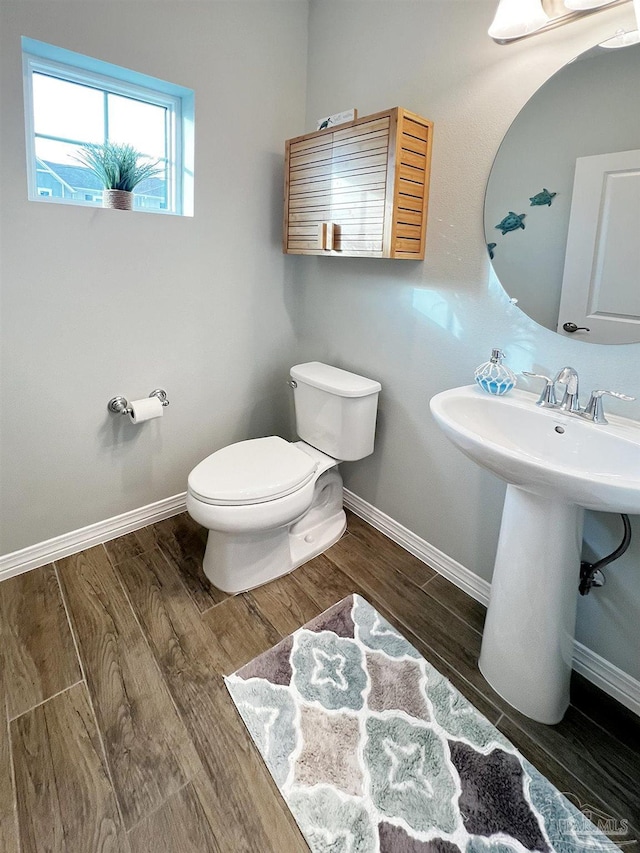 bathroom with sink, hardwood / wood-style floors, and toilet