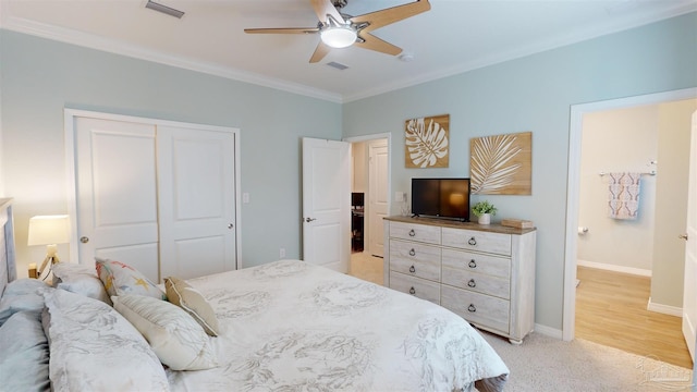 bedroom with ceiling fan, connected bathroom, ornamental molding, light colored carpet, and a closet