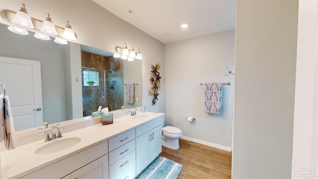 bathroom featuring wood-type flooring, toilet, an enclosed shower, and vanity