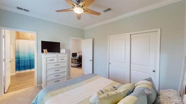 bedroom featuring ceiling fan, ornamental molding, light carpet, and a closet