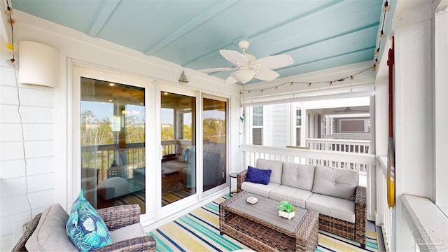 sunroom / solarium featuring beam ceiling and ceiling fan