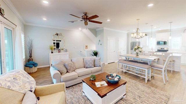 living room featuring crown molding, ceiling fan with notable chandelier, and light wood-type flooring