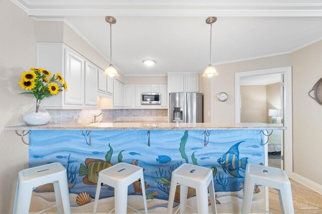 1111 Ft Pickens Rd Unit 111, Pensacola Beach, FL 32561 - kitchen featuring appliances with stainless steel finishes, decorative backsplash, a kitchen bar, light stone counters, and ornamental molding
