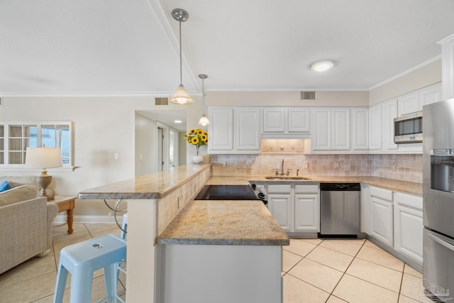 1111 Ft Pickens Rd Unit 111, Pensacola Beach, FL 32561 - kitchen with appliances with stainless steel finishes, a peninsula, light tile patterned floors, decorative backsplash, and crown molding