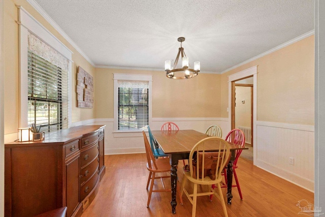 dining space featuring a healthy amount of sunlight, ornamental molding, and light wood-type flooring