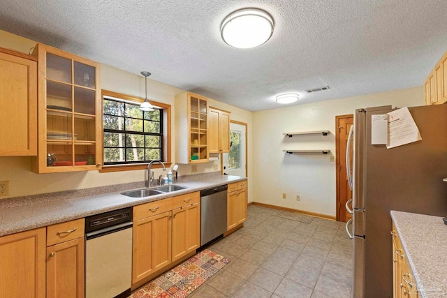 kitchen featuring light brown cabinets, hanging light fixtures, stainless steel appliances, sink, and a textured ceiling