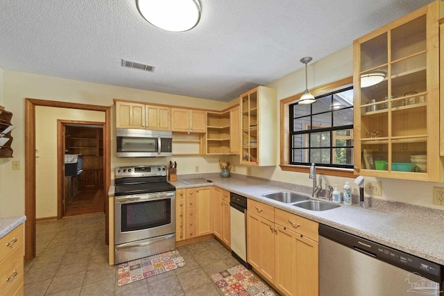 kitchen featuring visible vents, light brown cabinets, appliances with stainless steel finishes, and a sink